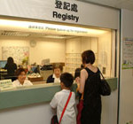 Patient and his parent is giving information at the clinic registry.